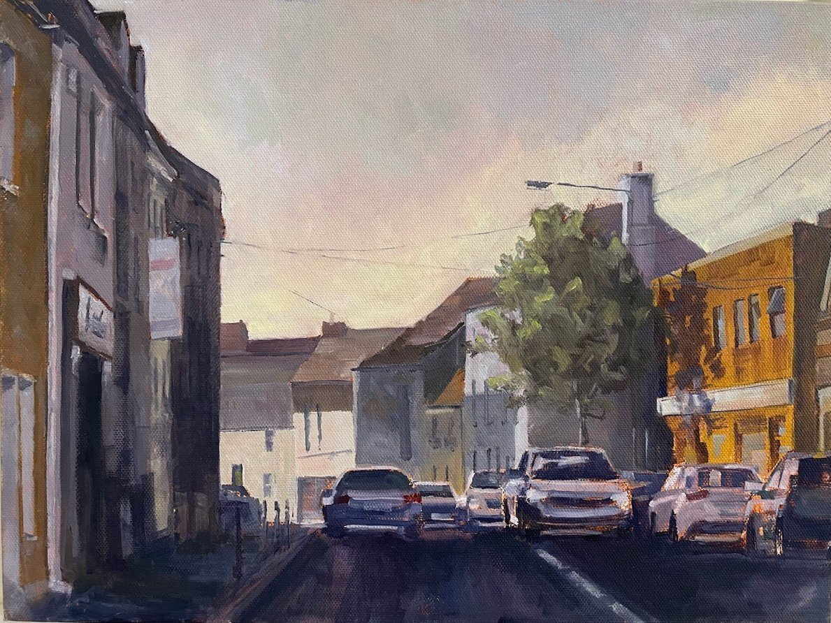 Painting of a quiet town street with parked cars and storefronts